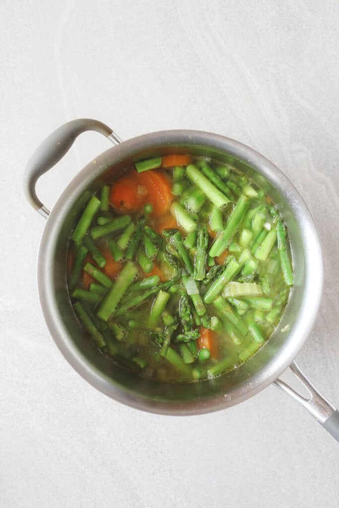 Asparagus in large pot with water and sweet potatoes, celery, onions, and garlic.