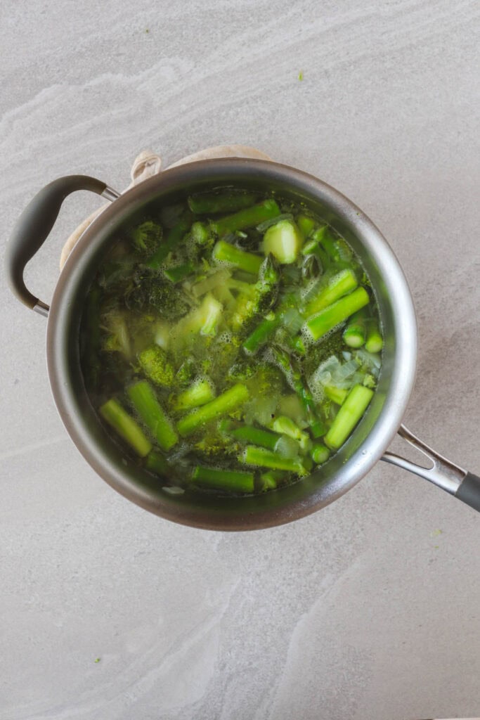 onion, celery, garlic, potatoes, broccoli and asparagus in pot with water