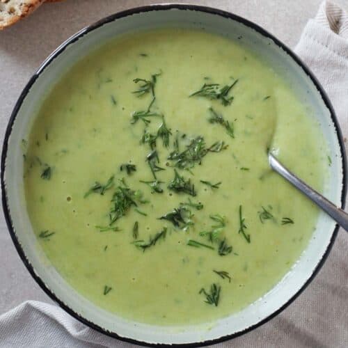 Creamy asparagus soup with dill in bowl with spoon