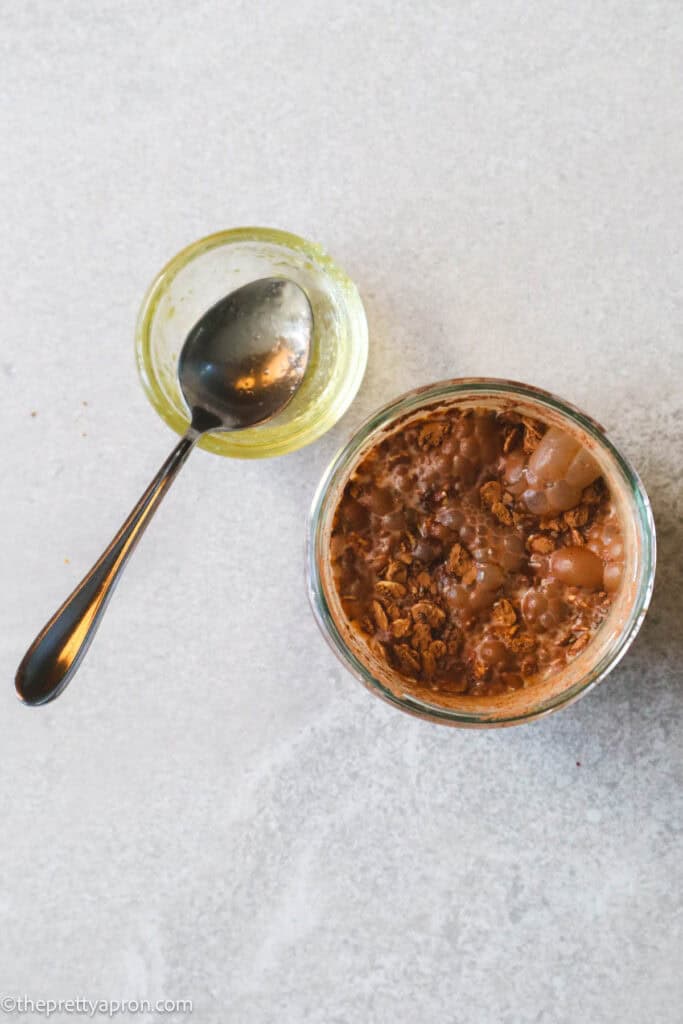 Oats, cacao powder, chia seeds, milk, honey in glass jar