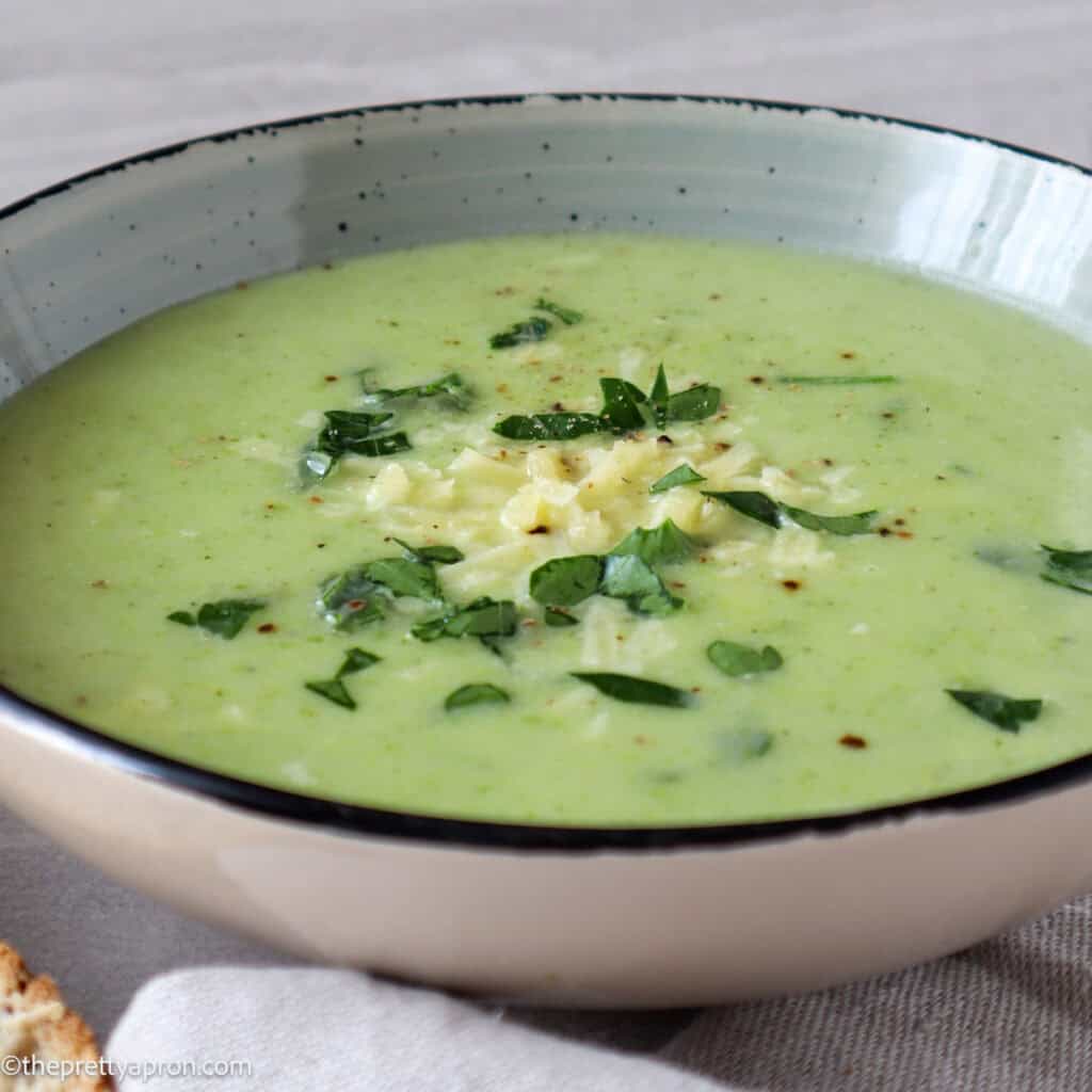 Creamy broccoli asparagus soup with grated parmesan cheese and chopped parsley