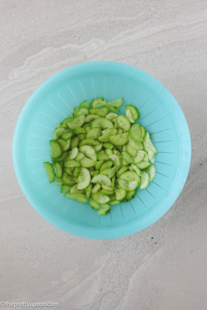 Draining cucumbers in blue colander