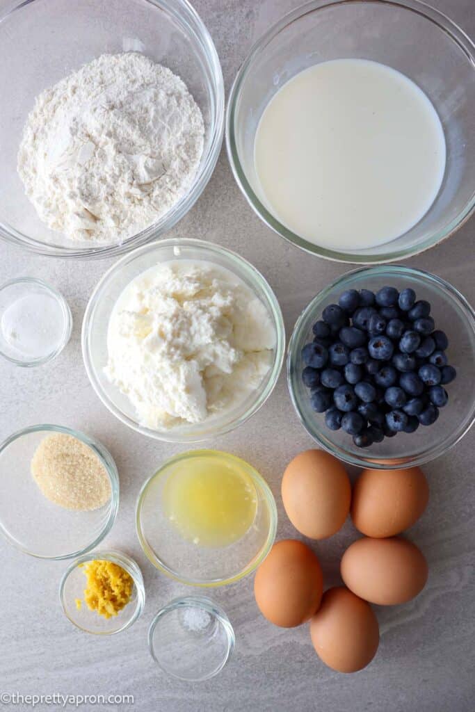 Lemon ricotta blueberry pancakes ingredients: flour, baking powder, milk, ricotta cheese, bllueberries, sugar, lemon zest and juice, eggs and salt