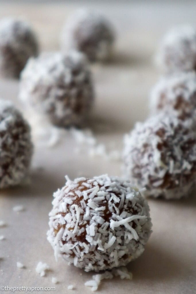 Lemon energy balls coated in coconut on wooden board