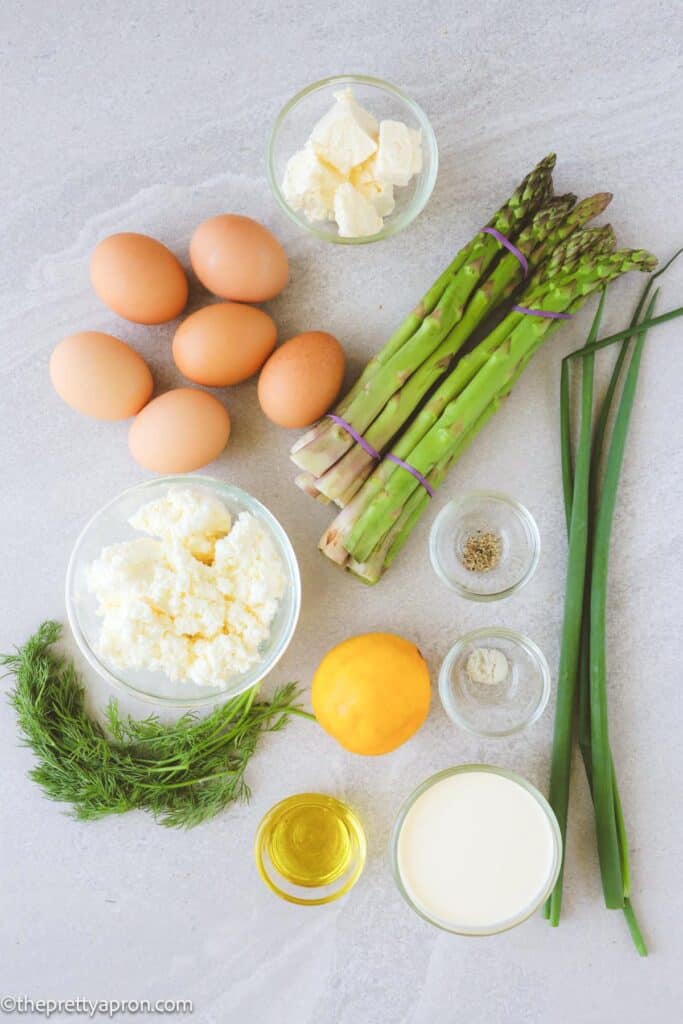 Ingredients for asparagus ricotta quiche with phyllo dough including eggs, ricotta cheese, phyllo dough, cream, salt, pepper, lemon, butter, dill and spring onions or chives and feta cheese
