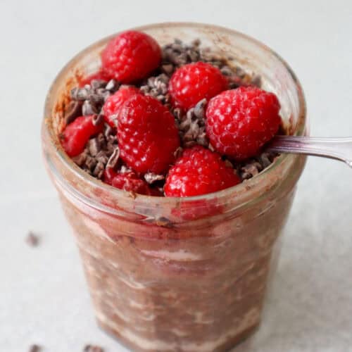 raspberry chocolate overnight oats in glass jar with spoon