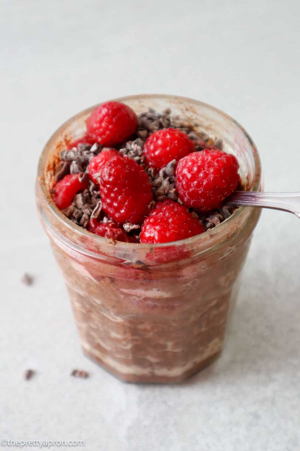 raspberry chocolate overnight oats in glass jar with spoon