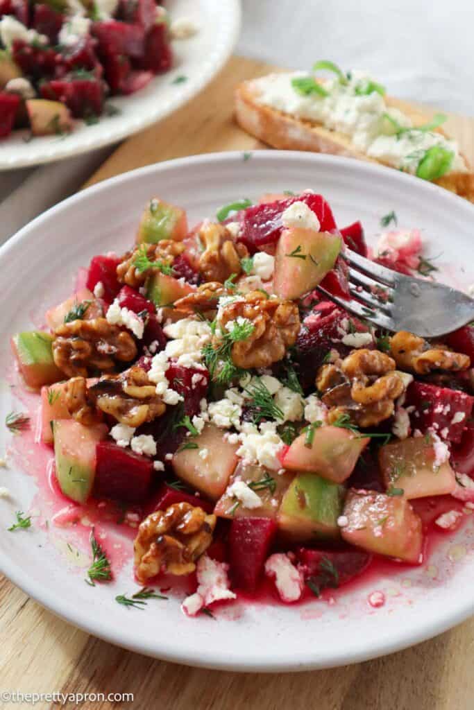 Forkful of cucumber beet salad with dill and walnuts and feta
