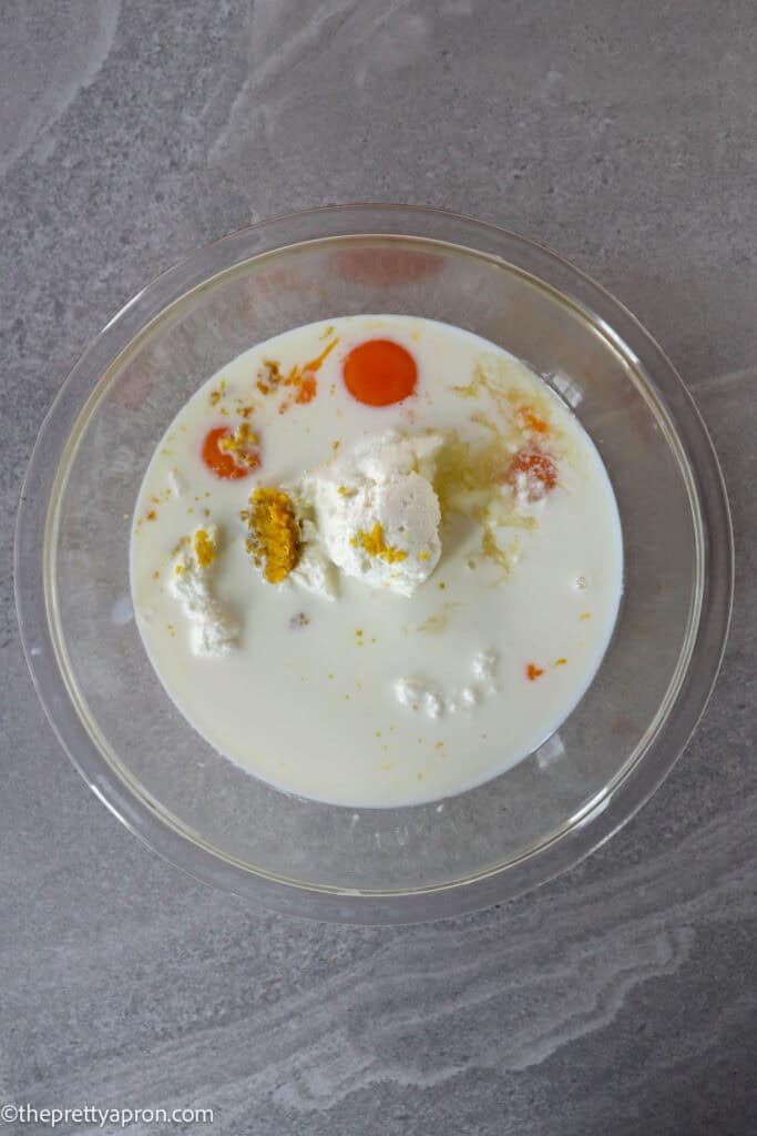 Egg yolks, ricotta cheese, milk, lemon zest and juice in bowl