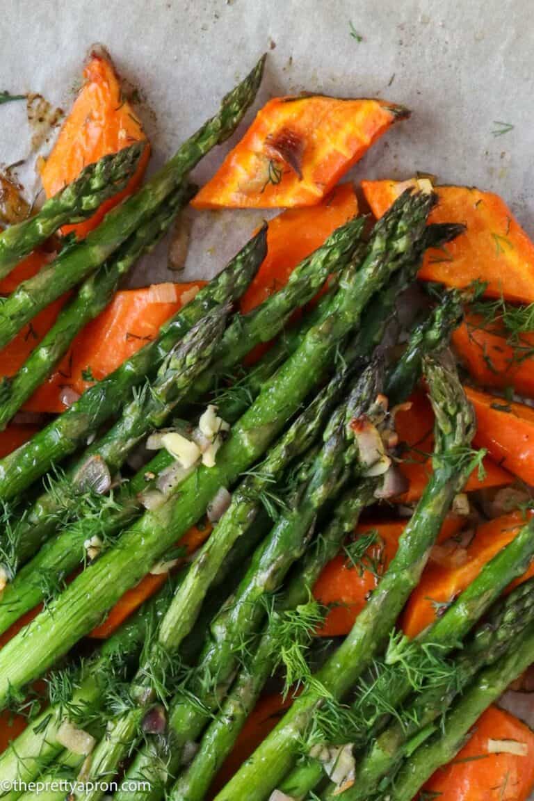 roasted asparagus and carrots on baking tray with fresh dill