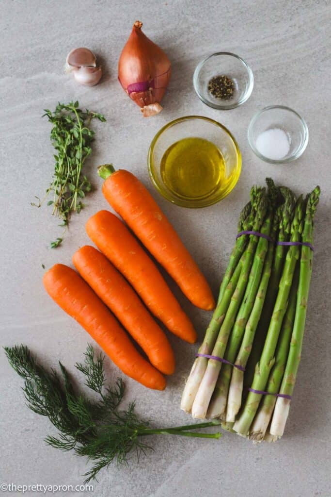 Ingredients for roasted carrots and asparagus including garlic, shallots, salt, pepper, asparagus, carrots, olive oil and dill