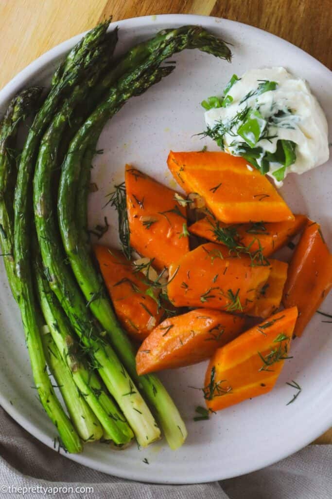 Roasted asparagus and carrots with ricotta cheese dip on white plate